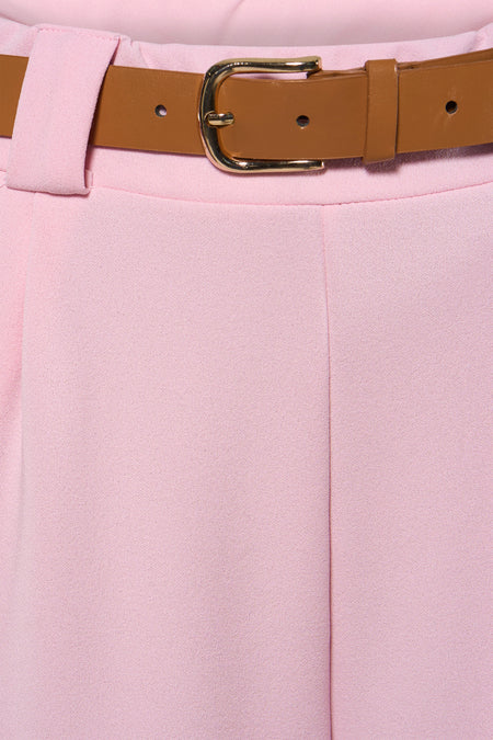 Roze broek van Terra di Siena, met een bruine riem met gouden gesp rond de taille.
