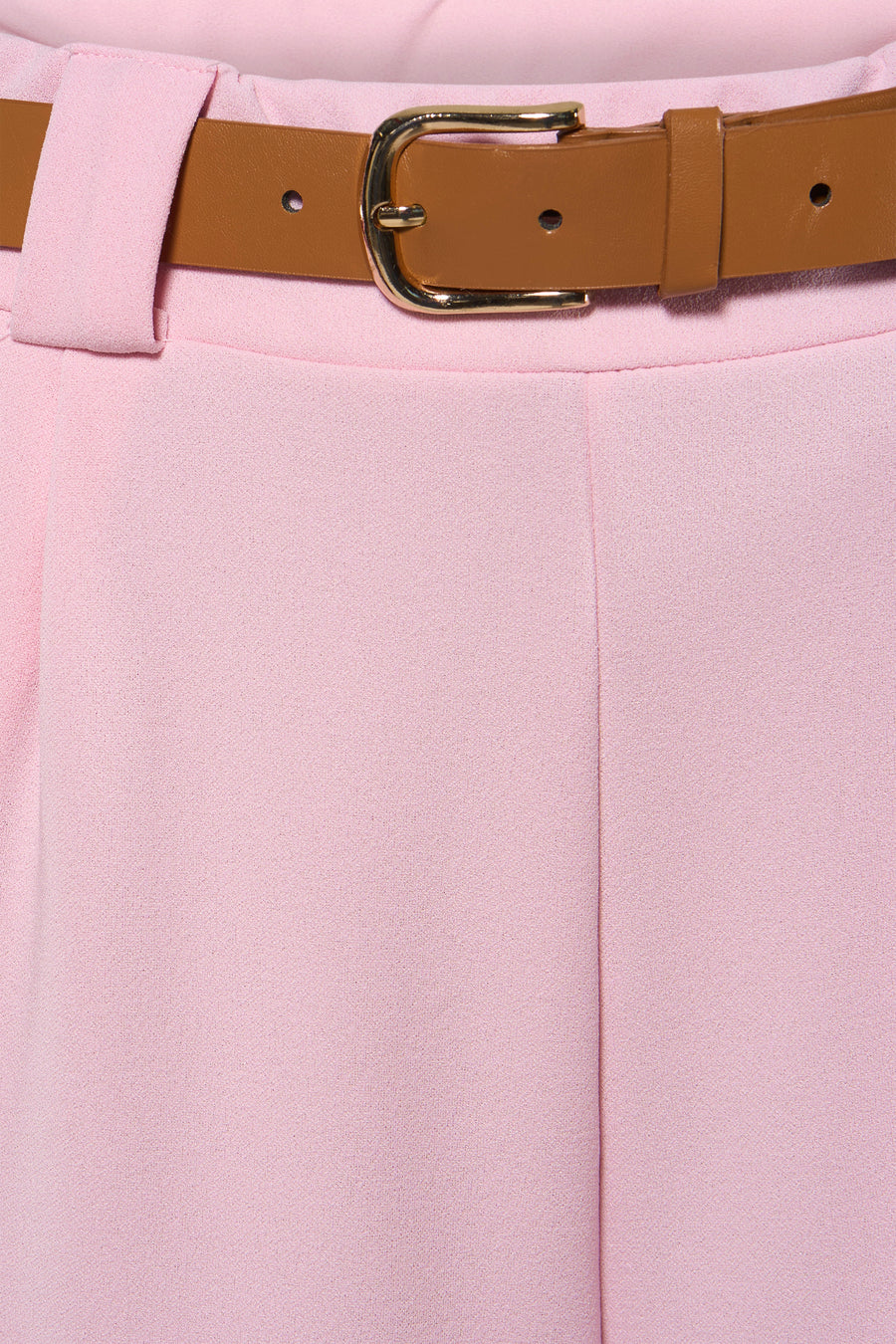 Pantalon rose de Terra di Siena, avec une ceinture marron à boucle dorée autour de la taille.