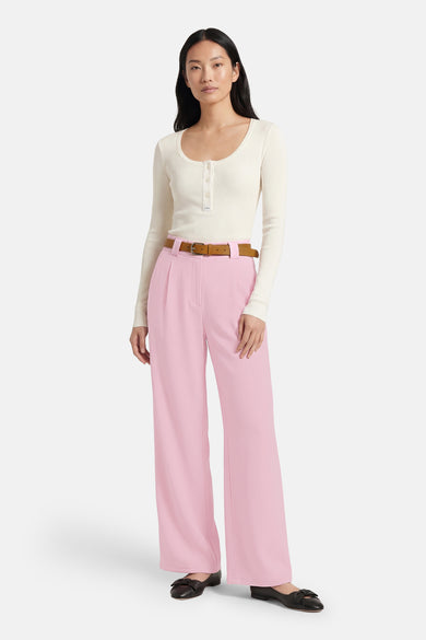 Roze broek van Terra di Siena, gecombineerd met een bruine riem en zwarte schoenen.