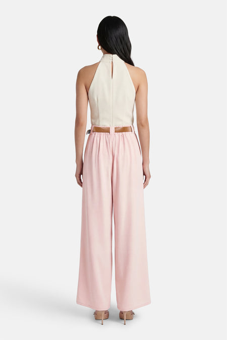 Pantalon de costume rose de Terra di Siena, avec une ceinture marron, des jambes larges et des talons nude.