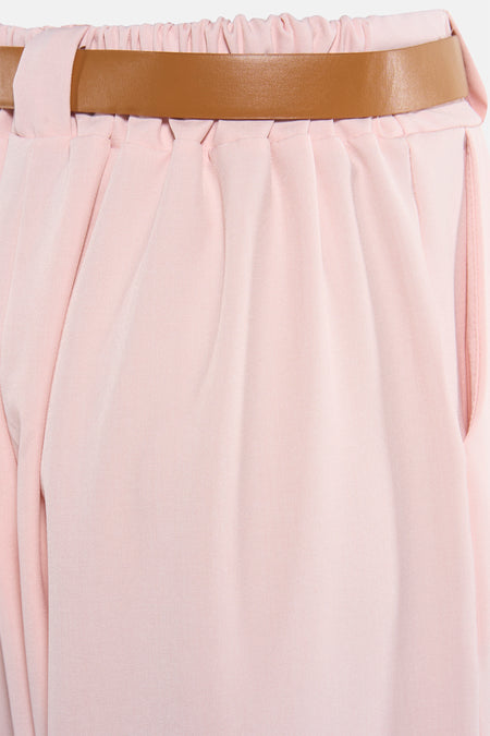 Roze kostuumbroek van Terra di Siena, met een bruine riem, geplooide taille en een zijzak.
