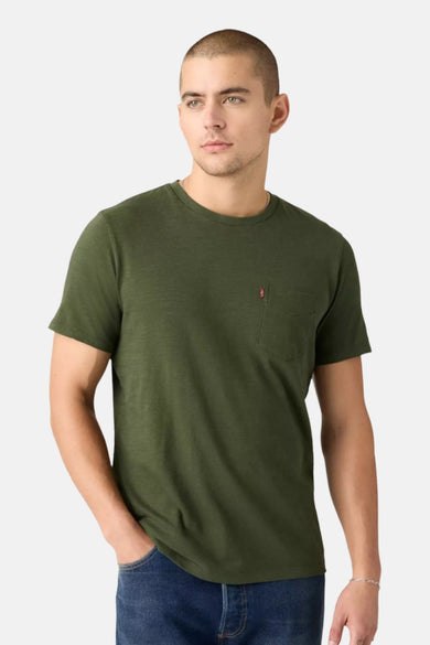 Groen T-shirt met korte mouwen van Levi's, met een borstzakje en gedragen met een jeans.
