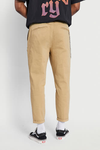 Beige broek van REDEFINED REBEL, met omgeslagen pijpen en zilverkleurige ketting.