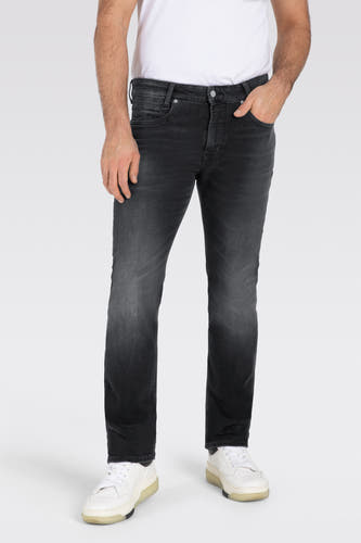 Donkergrijze straight jeans van MAC, met subtiele vervaging en gedragen met een wit T-shirt en witte sneakers.
