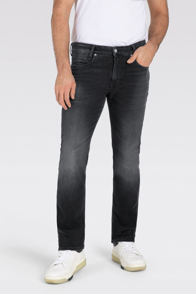 Donkergrijze straight jeans van MAC, met subtiele vervaging en gedragen met een wit T-shirt en witte sneakers.
