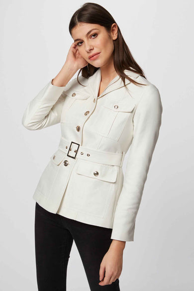 Witte korte jas van Morgan De Toi, met riem en zakken, gecombineerd met een zwarte broek.