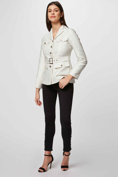 Witte korte jas van Morgan De Toi, met riem en zakken, gedragen met zwarte broek en hakken.
