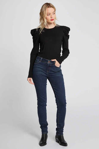 Jean skinny bleu de Morgan De Toi, porté avec un pull noir à manches ballon et des bottines noires.