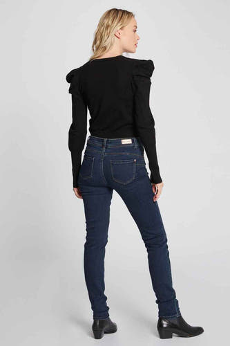 Jean skinny bleu de Morgan De Toi, vu de l'arrière, associé à une chemise noire et des bottes.