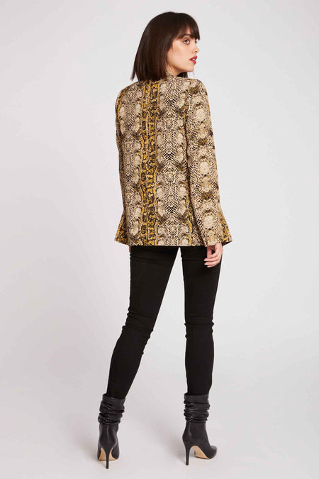 Multikleurige blazer van Morgan De Toi, met slangenprint en gedragen met zwarte broek en laarzen met hakken.
