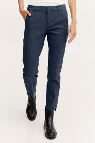 Blauwe chino van Fransa, gecombineerd met zwarte laarzen en een wit hemd.
