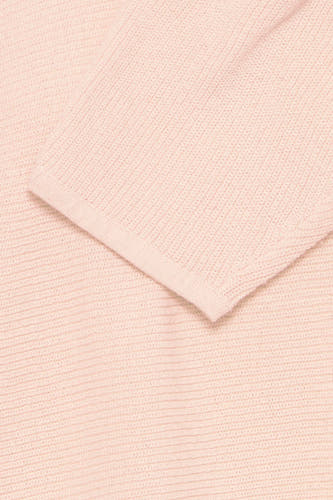 Pull-over rond en rose de France, avec une fine texture tricotée dans un plan rapproché.