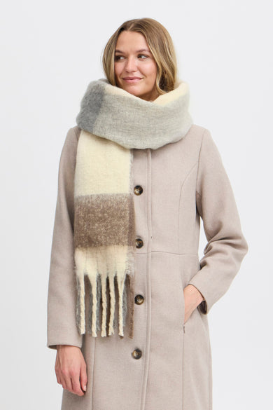 Beige winterjas van Fransa, met een grote geblokte sjaal in grijs, bruin en wit.
