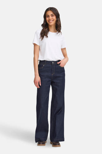 Jean denim bleu marine avec des jambes larges de France, porté avec un T-shirt blanc et des chaussures marron.