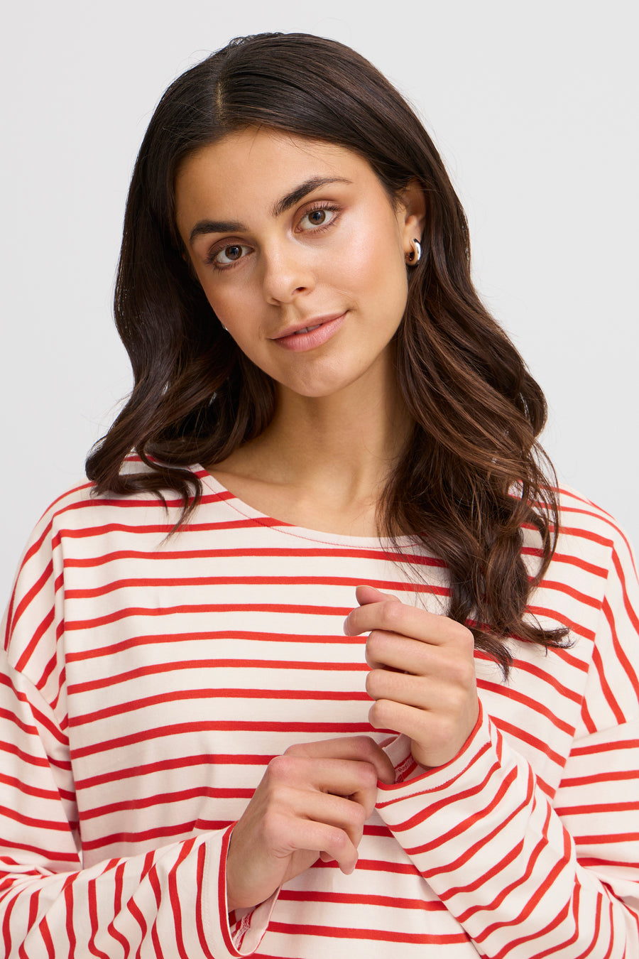 T-shirt rayé rouge avec des manches longues de Fransa, avec un col rond et une femme avec des boucles d'oreilles en argent.