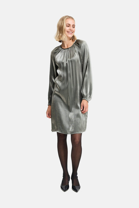 Zilverkleurige jurk met lange mouwen van Fransa, gedragen met zwarte panty en pumps.
