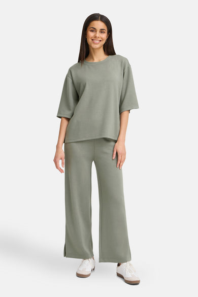 Pull-over vert avec col rond de France, décontracté et associé à un pantalon coordonné.