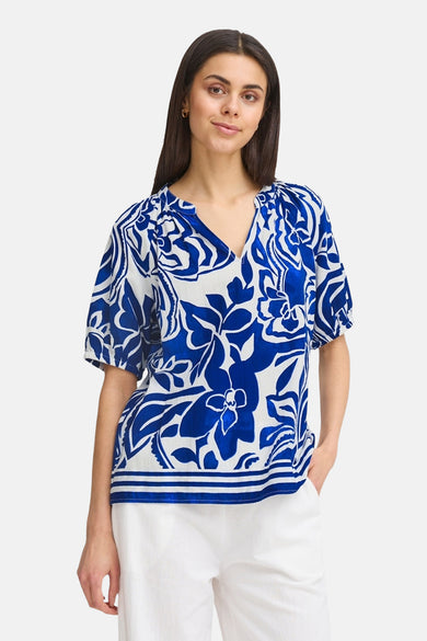 Blouse bleue de France avec imprimé fleuri, manches courtes et col V.