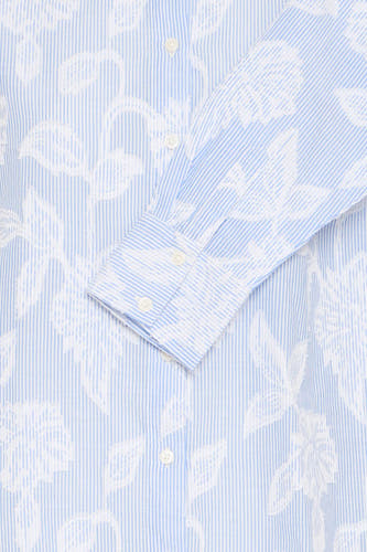 Chemise bleue à manches longues de France, avec des fleurs blanches et un détail de nœud sur la manche.