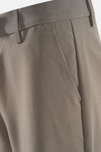 Pantalon brun de France, gros plan sur la ceinture et la poche, avec une subtile texture.