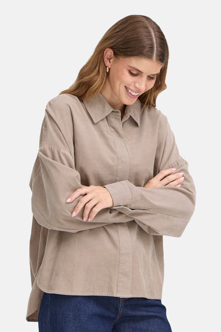 Chemise brune à longues manches en coton français, avec un tissu de laine et des manches longues croisées devant la poitrine.