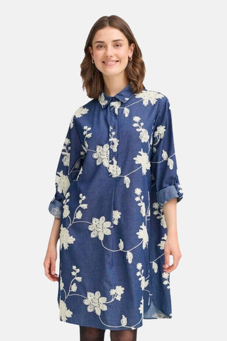 Robe bleue à longues manches en France, avec un motif de fleurs blanches.
