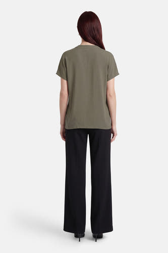 Chemisier à manches courtes de Fransa®, vu de dos, combiné avec un pantalon noir et des talons.