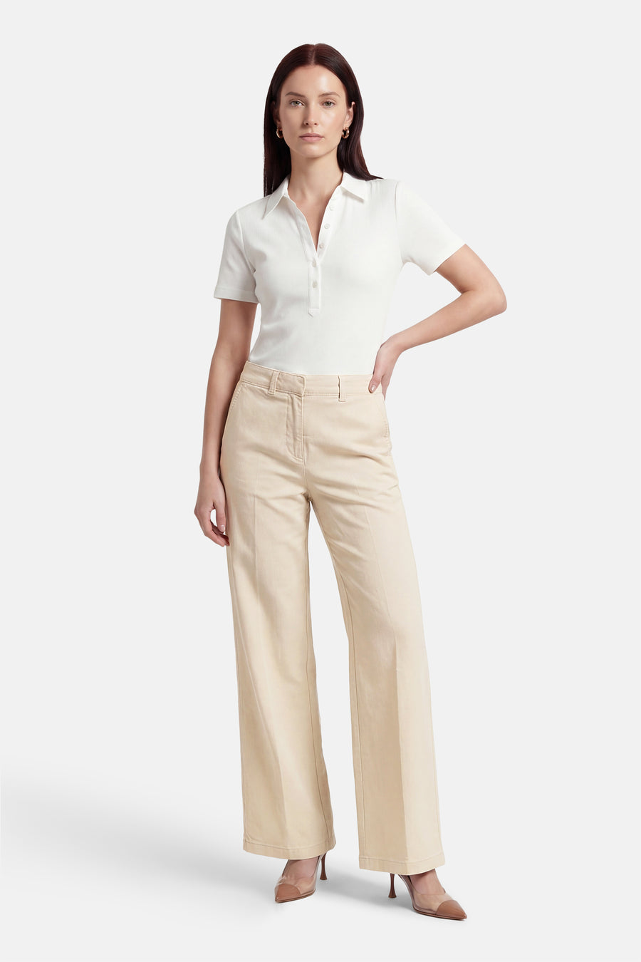 Ecru broek van Fransa, met wijde pijpen en zichtbare stiksels, gecombineerd met een witte polo en pumps.