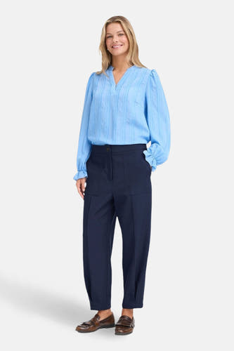 Blauwe broek van Fransa met rechte pijpen en zakken, gecombineerd met een lichtblauwe blouse en bruine loafers.
