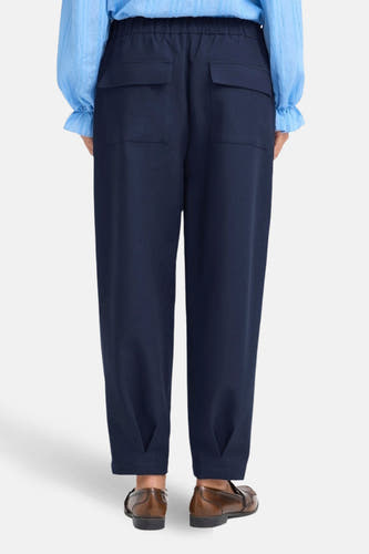 Blauwe broek van Fransa, met twee opgestikte achterzakken en bruine schoenen.
