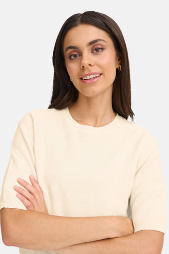 Gilet beige avec col rond en France, avec des bras croisés