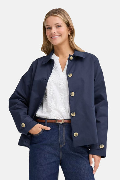Veste courte bleue de Fransa, à manches longues et avec un col, portée sur un jean foncé.