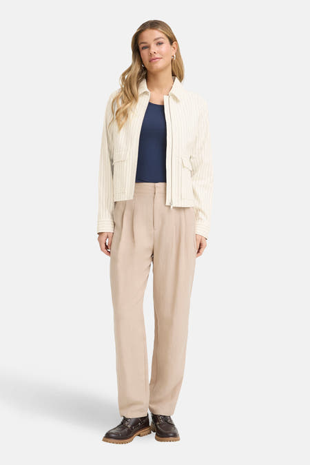 Korte ecru jas van Fransa, met pinstrepen en opgestikte zakken, gecombineerd met een blauw shirt en beige pantalon.