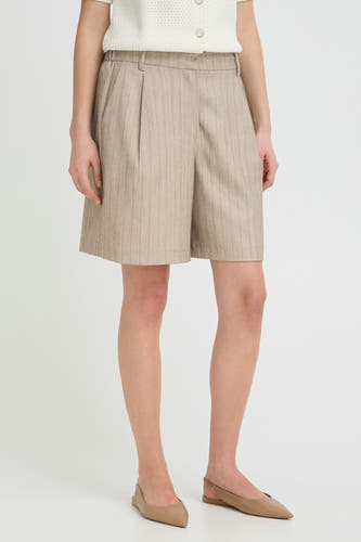 Short beige de Fransa, avec des rayures verticales et un devant plissé, combiné avec des chaussures plates.