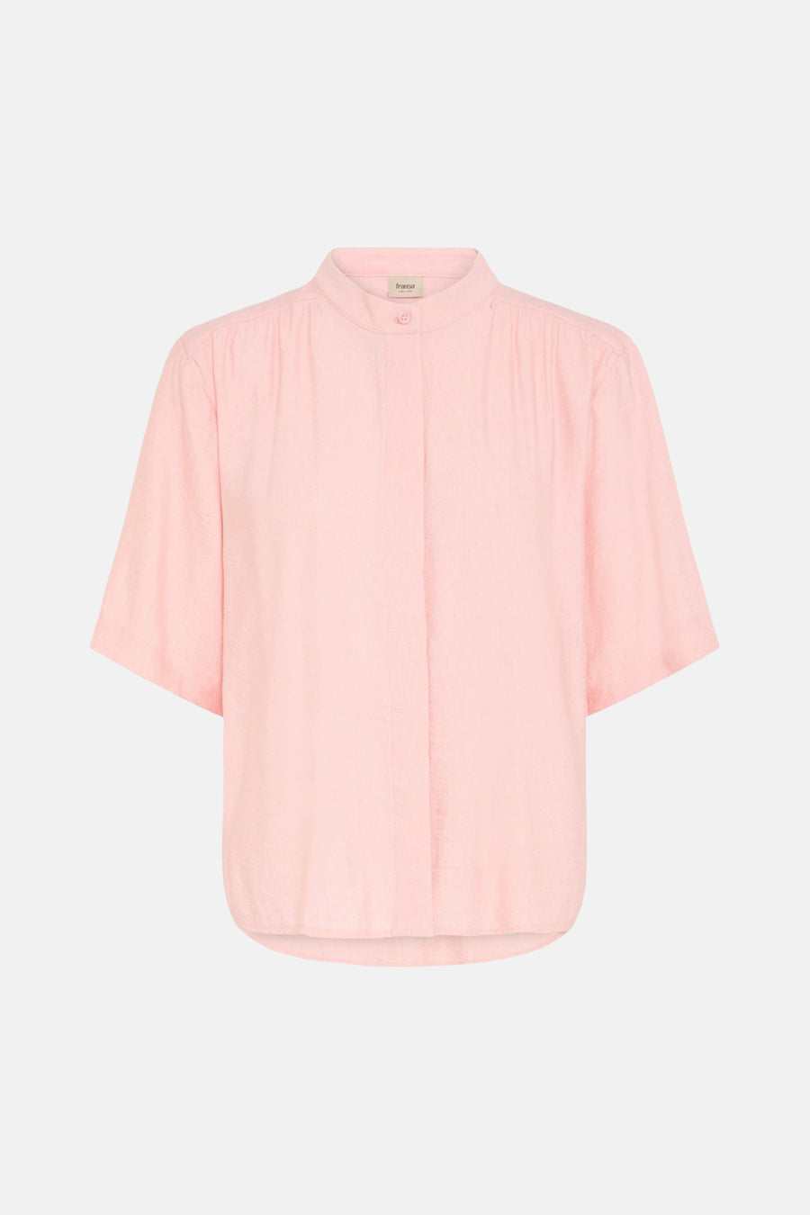 Chemise rose à manches courtes de Fransa® avec texture légère et col mao, portée par un mannequin avec un pantalon beige dans un cadre lifestyle.