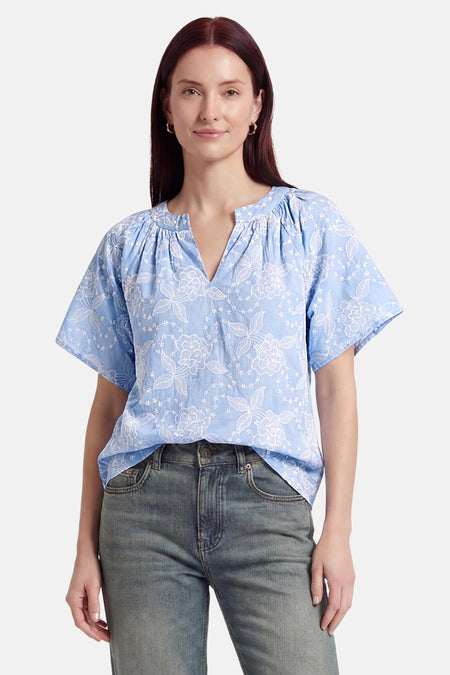 Blauwe blouse met korte mouwen van Fransa, met witte bloemenborduursels, V-hals en gerimpelde halslijn.