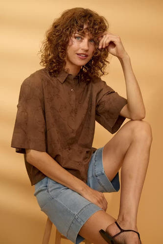 Bruin korte mouwen overhemd van Fransa® met subtiel patroon, gedragen met jeansshorts, zittend op houten kruk, lifestyle shot