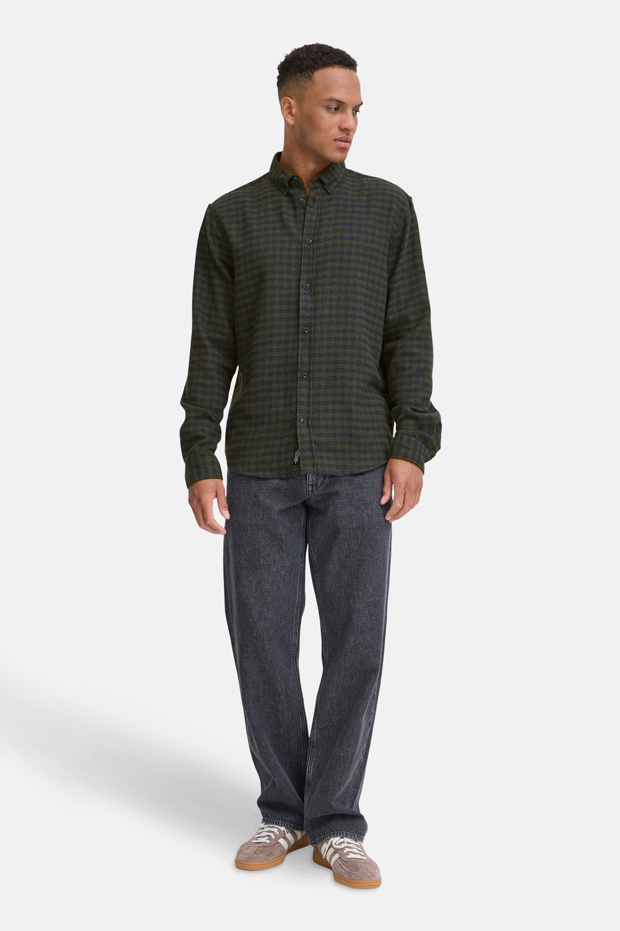 Man in geruite shirt en grijze jeans.