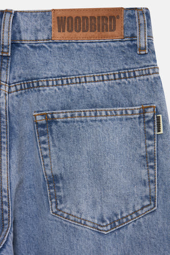 Jean bleu clair large de WOODBIRD, avec poche arrière et patch logo.
