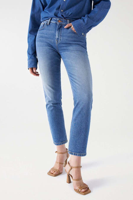 Jean slim de denim bleu clair de Salsa Jeans, associé à une chemise en denim bleu et des sandales brunes.