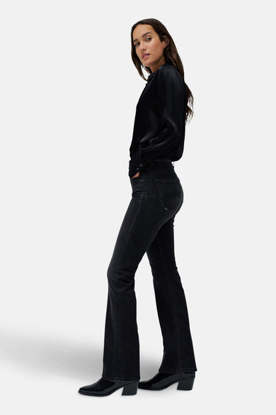 Bootcut jeans van donkergrijs denim van Salsa Jeans, met subtiele details en gecombineerd met een zwarte blouse en laarzen.