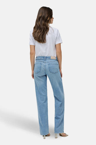 Lichtblauwe straight jeans van Salsa Jeans, gezien van achteren, met een wit t-shirt en hakken.