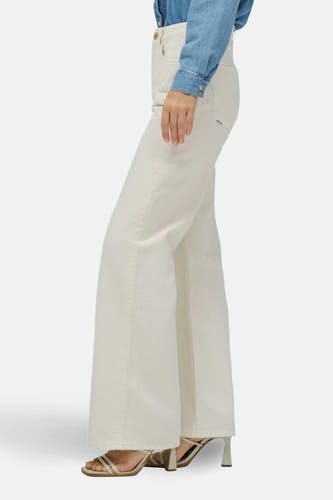 Off white denim wijde jeans van Salsa Jeans, gedragen met een blauw denim shirt en gouden hakken.