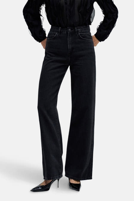 Jeanon de de large de Salsa Jeans, avec des jambes qui s'élargissent et porté avec une blouse noire et des escarpins.