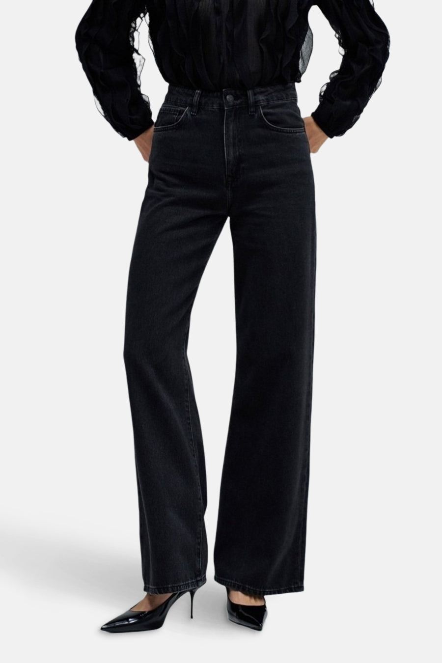 Donkergrijze wide jeans van Salsa Jeans, gedragen met een zwarte blouse en zwarte pumps.