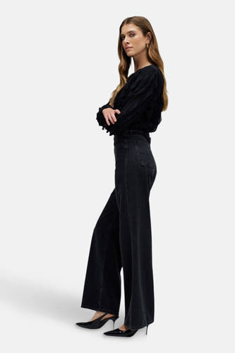 Donkergrijze wide jeans van Salsa Jeans, met wijde pijpen en gedragen met zwarte hakken.