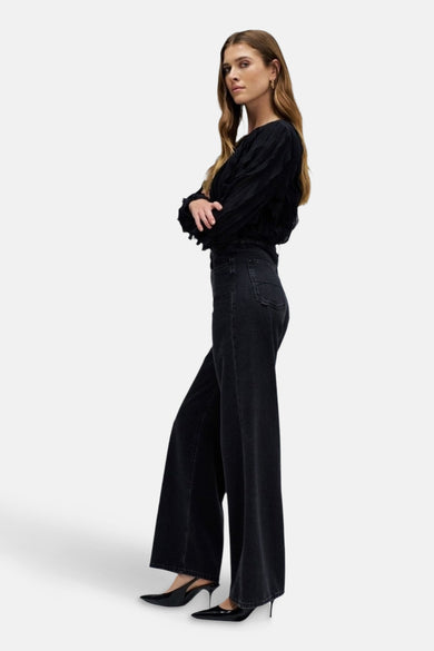 Donkergrijze wide jeans van Salsa Jeans, met wijde pijpen en gedragen met zwarte hakken.