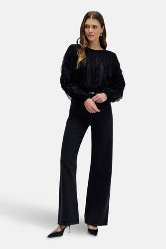 Donkergrijze wijde jeans van Salsa Jeans, met uitlopende pijpen en gedragen met zwarte blouse en pumps.
