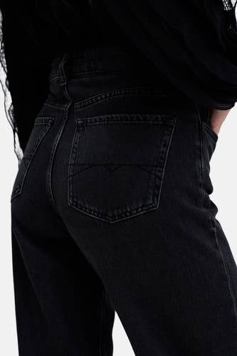 Donkergrijze wide jeans van Salsa Jeans, met achterzak en tailleband, detail van een zwart bovenstuk.
