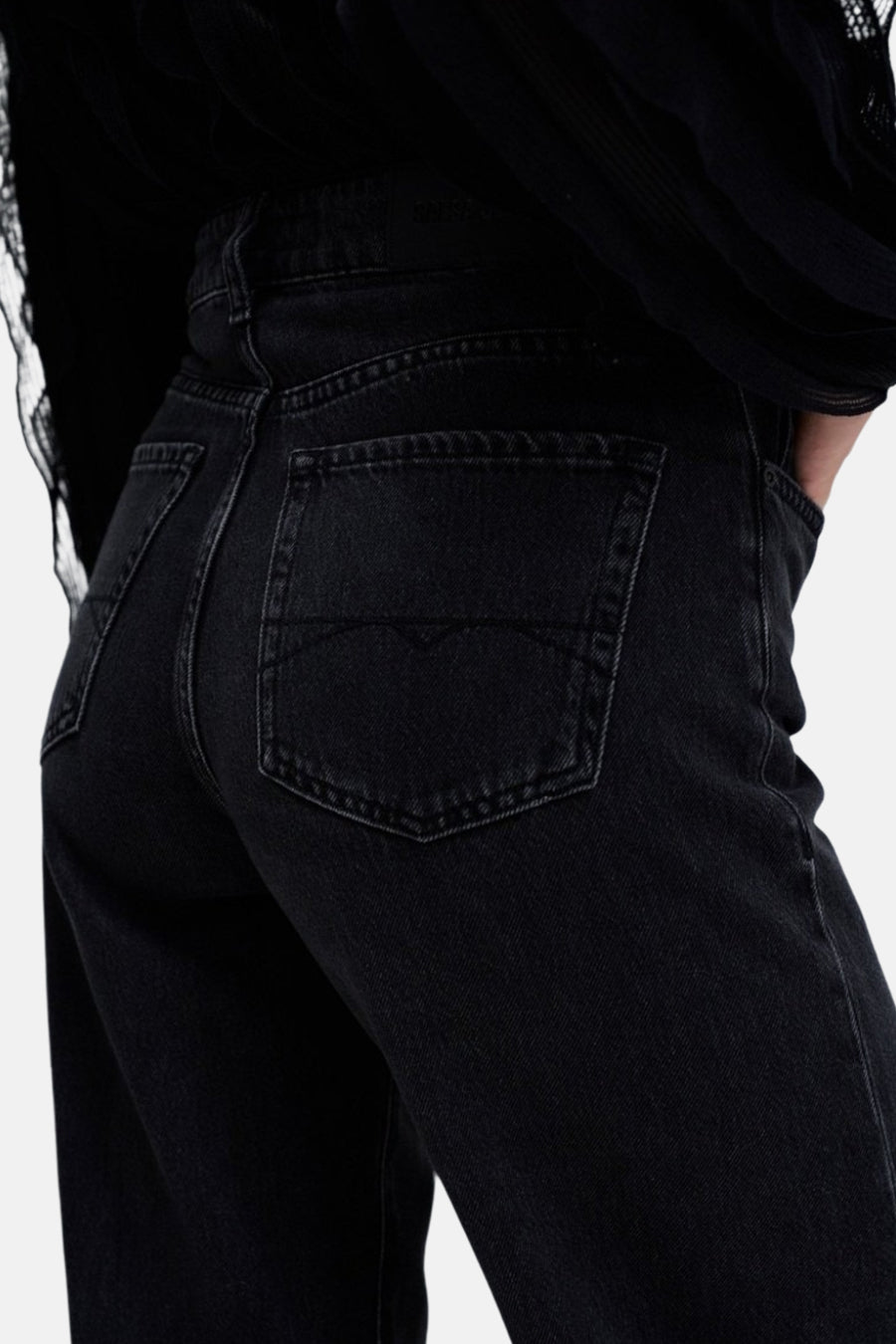 Donkergrijze wide jeans van Salsa Jeans, met achterzak en tailleband, detail van een zwart bovenstuk.
